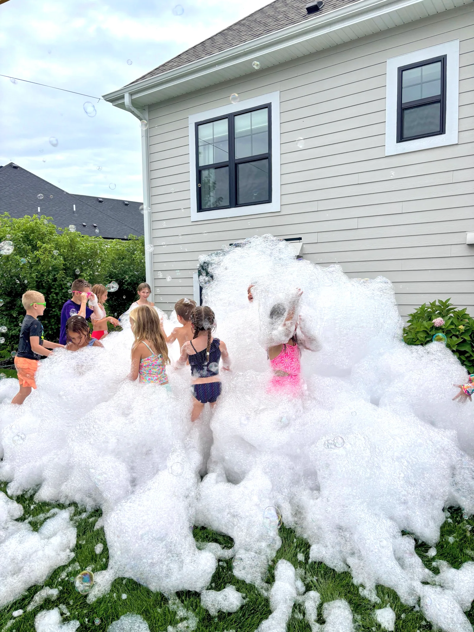 Kids birthday foam party in a sunny backyard